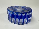 a blue glass container with a flower design on it