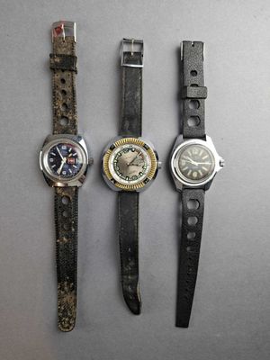 three different types of watches are displayed on a gray surface