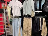 beaucoup de vêtements suspendus à une étagère dans un magasin