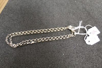 une chaîne en argent à laquelle est accrochée une médaille, posée sur une table