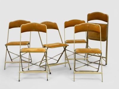 four chairs are lined up in a row on a white surface