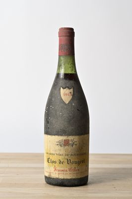 bottles of wine on a wooden table with a white wall in the background