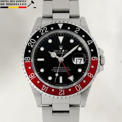 a watch with a red and black bezel on it