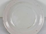 a white plate with a black rim sitting on a table
