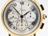 a close up of a gold wrist watch with roman numerals