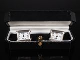pair of silver cuff watches in a black box on a black surface