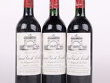 trois bouteilles de vin rouge posées l'une à côté de l'autre sur une surface blanche