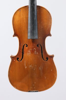 an old violin sitting on top of a white surface