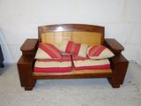 a wooden bench with two pillows on it in a room