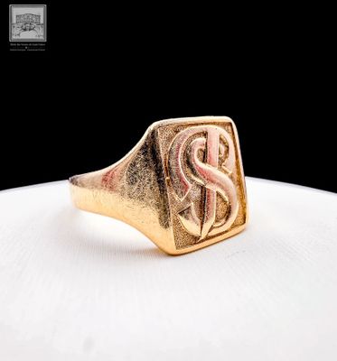 a close up of a gold signet ring with the letter s on it
