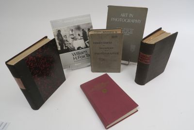 several books are sitting on a white surface with a white background
