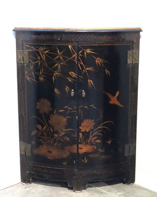 une armoire noire décorée de fleurs et d'oiseaux peints