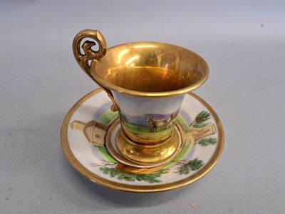 a gold cup and saucer on a white table