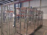 a large metal cage in the middle of a warehouse