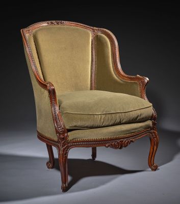 an antique chair with a green upholstered seat and a wooden frame