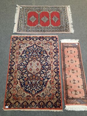 trois tapis orientaux et un tapis au sol
