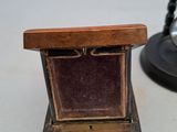 a small wooden box with a ring inside of it