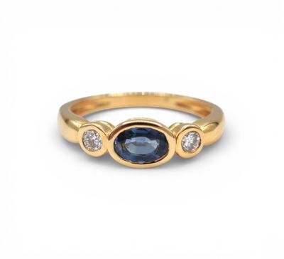 a yellow gold ring with a blue sapphire and three diamonds