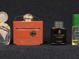 many different types of perfume bottles lined up on a black surface