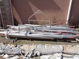 a pile of bags of cement next to a pile of pipes
