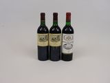 trois bouteilles de vin posées les unes à côté des autres sur une surface blanche
