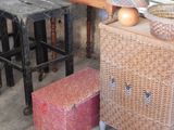 a wicker box and a wooden stool in a room