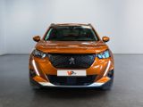 an orange car is parked in a large room with a white wall