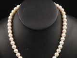 un collier de perles blanches sur un mannequin noir