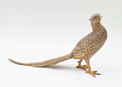 un oiseau de couleur dorée posé sur une surface blanche