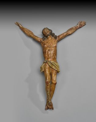 un gros plan d'une statue de Jésus sur une croix, accrochée à un mur