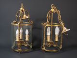 pair of antique brass and glass hanging lanterns on a black background