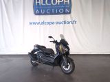 une photo d'un scooter garé devant un panneau « Alcoda Auction »