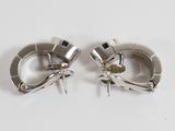 pair of silver plated earrings on white surface with white background
