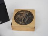 a small box with a stone in it next to a black box