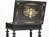 a black and gold writing desk with a gold lion on it