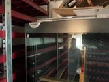 a man that is standing in front of a wine rack