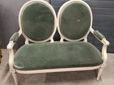 a green and white couch with two chairs on it