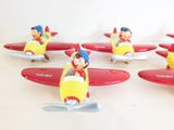 five small figurines of a boy riding a plane