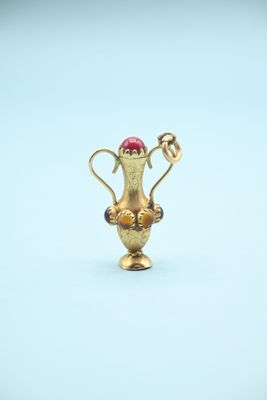 a gold trophy with a red ball in it