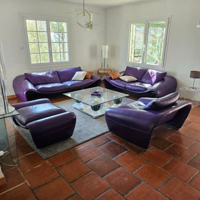 un salon avec des canapés violets et une table basse