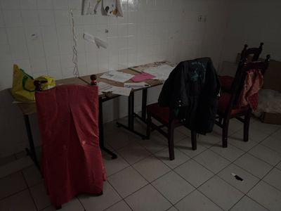deux chaises et une table dans une pièce aux carreaux blancs