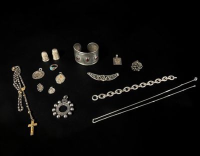 a collection of silver jewelry on a black background