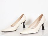 une paire de chaussures blanches à talons hauts sur une surface blanche