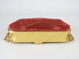 an antique gold and red box with a red velvet cover