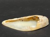 a small piece of white marble on a black surface