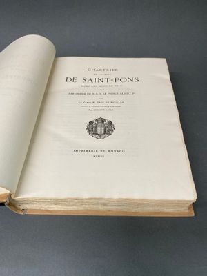 un livre ouvert posé sur une table à côté d'une table noire