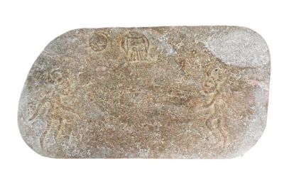 a stone with carvings on it on a white surface