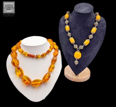deux colliers et un collier posé sur un présentoir pour mannequin