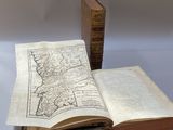 un livre ouvert posé sur une table à côté d'un livre