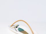 une assiette blanche décorée d'un oiseau bleu et d'un bord doré